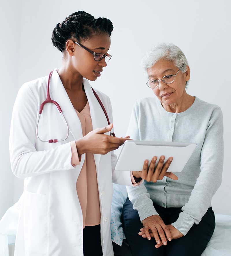 Young african american doctor talking with senior woman