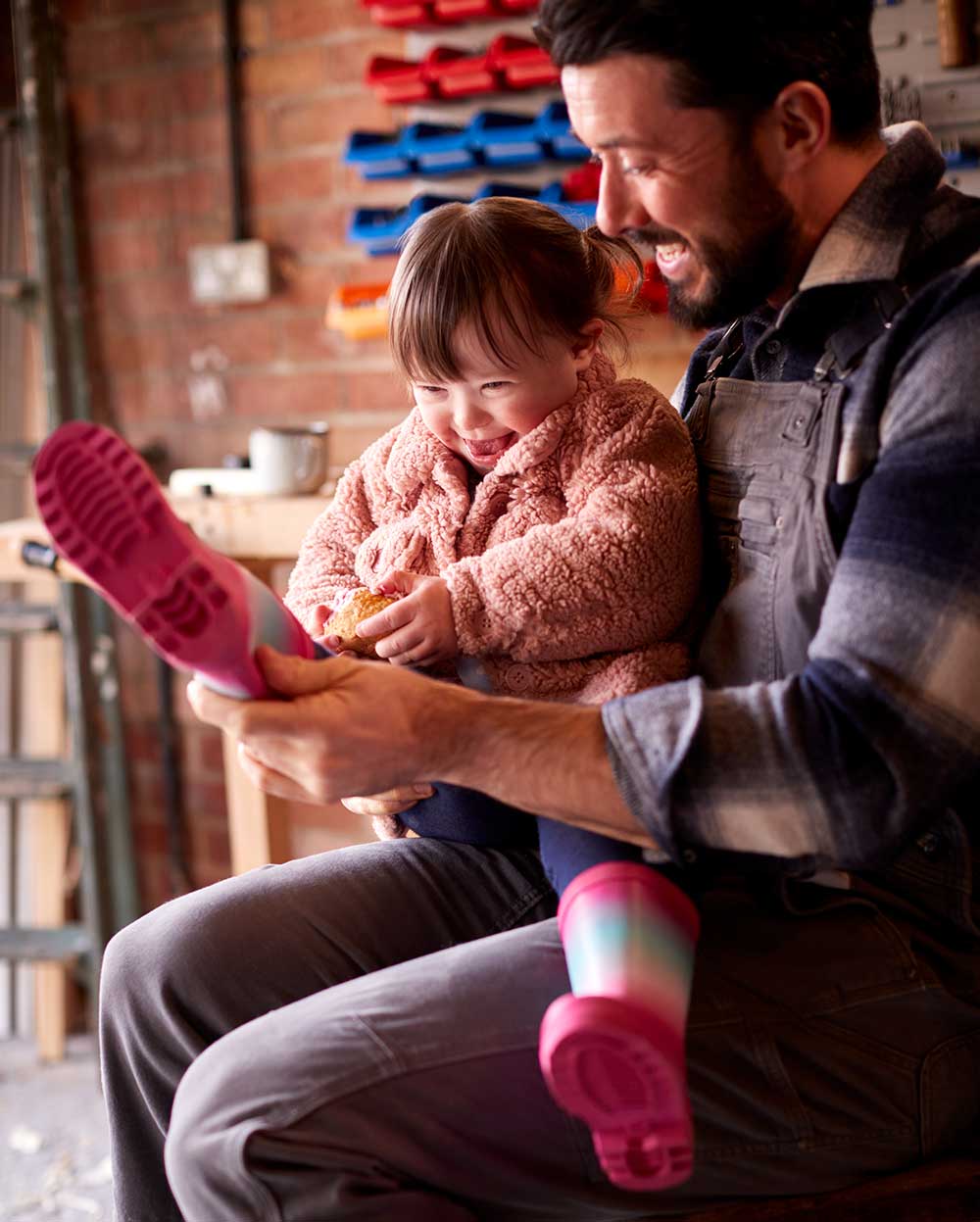 Father reading to special needs daughter, both smiling