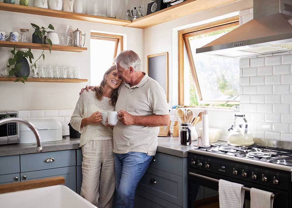 senior couple embracing in kitchen